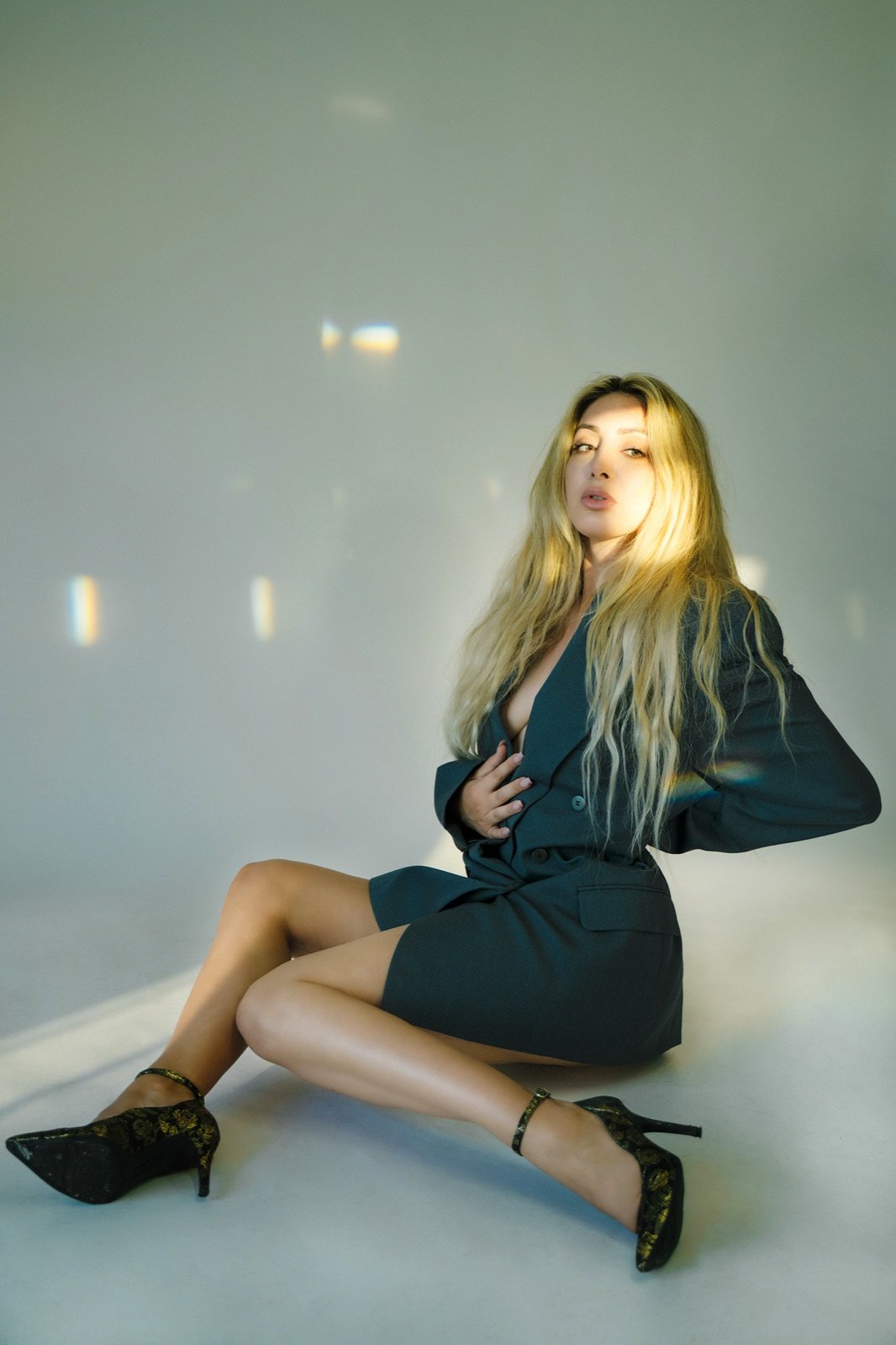 Black blazer dress, seated in the light