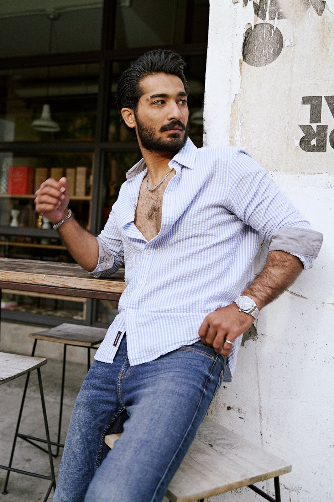 Striped shirt, leaning outside a cafe