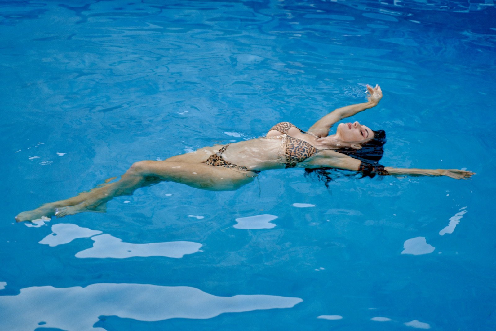 Floating on her back in the pool