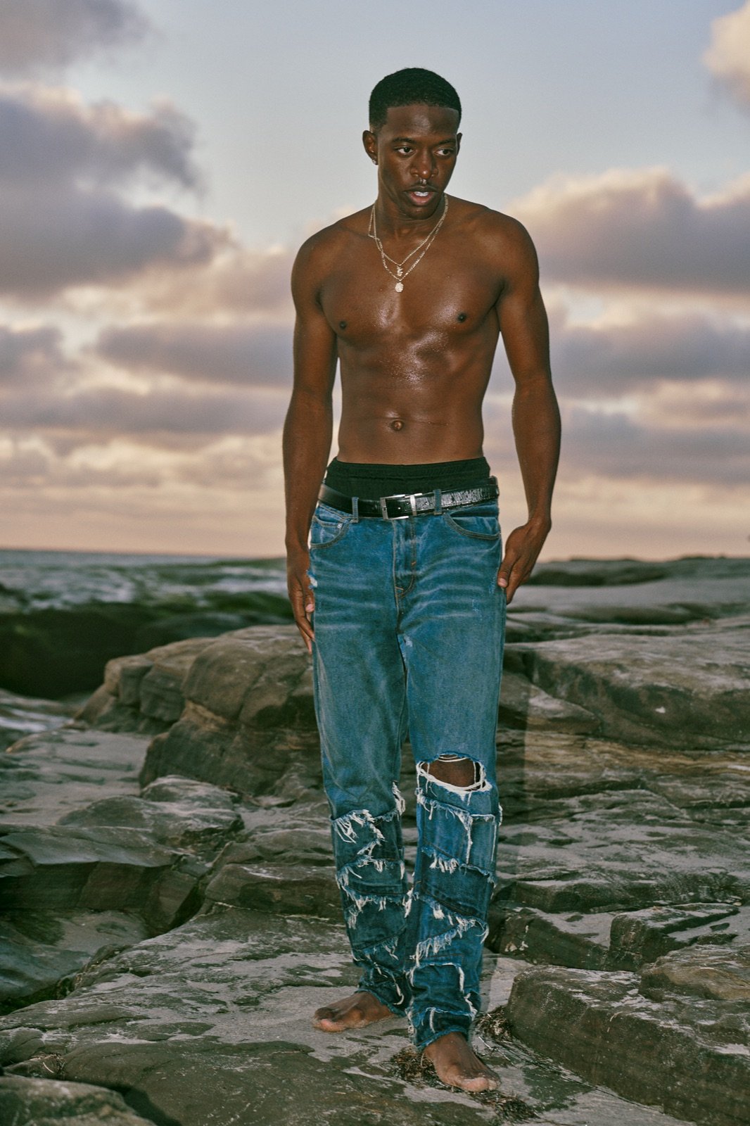 Ripped jeans on the rocks at sunset